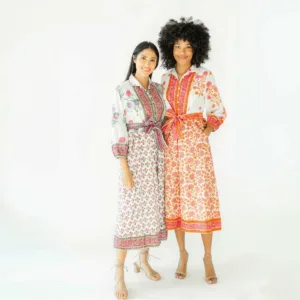 Two women in floral dresses posing together.
