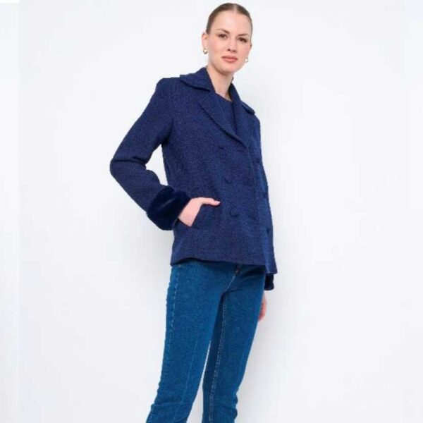 A woman wearing jeans and a midnight navy wool blend boucle double-breasted coat.